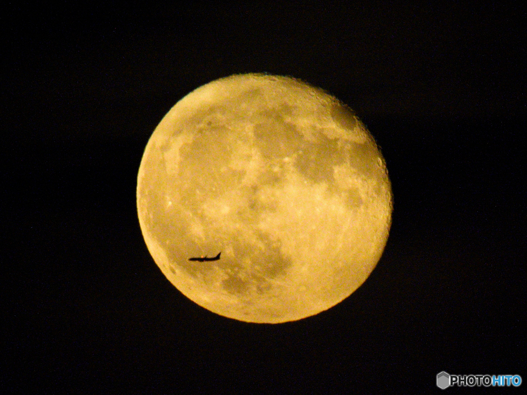 An airplane in front of the moon