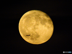 An airplane in front of the moon