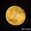 An airplane in front of the moon