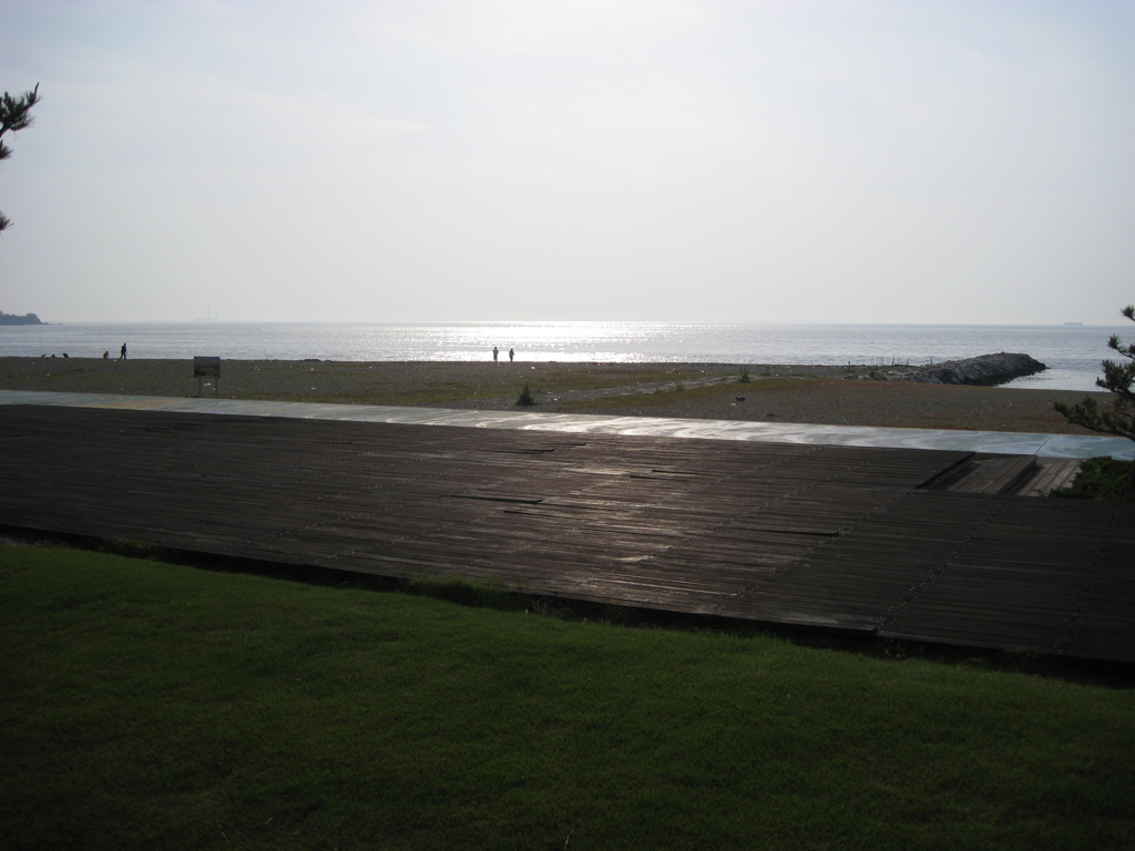 芝生とウッドデッキと砂浜と海と波のキラキラ