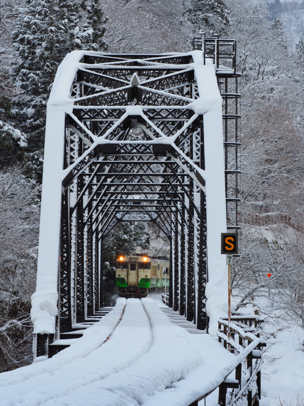 雪積もる鉄橋の向こうから
