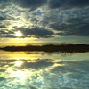 雲の隙間から光輝く沼の朝