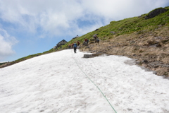 雪渓を行く