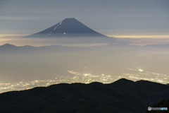 霞む街明かりと登山者