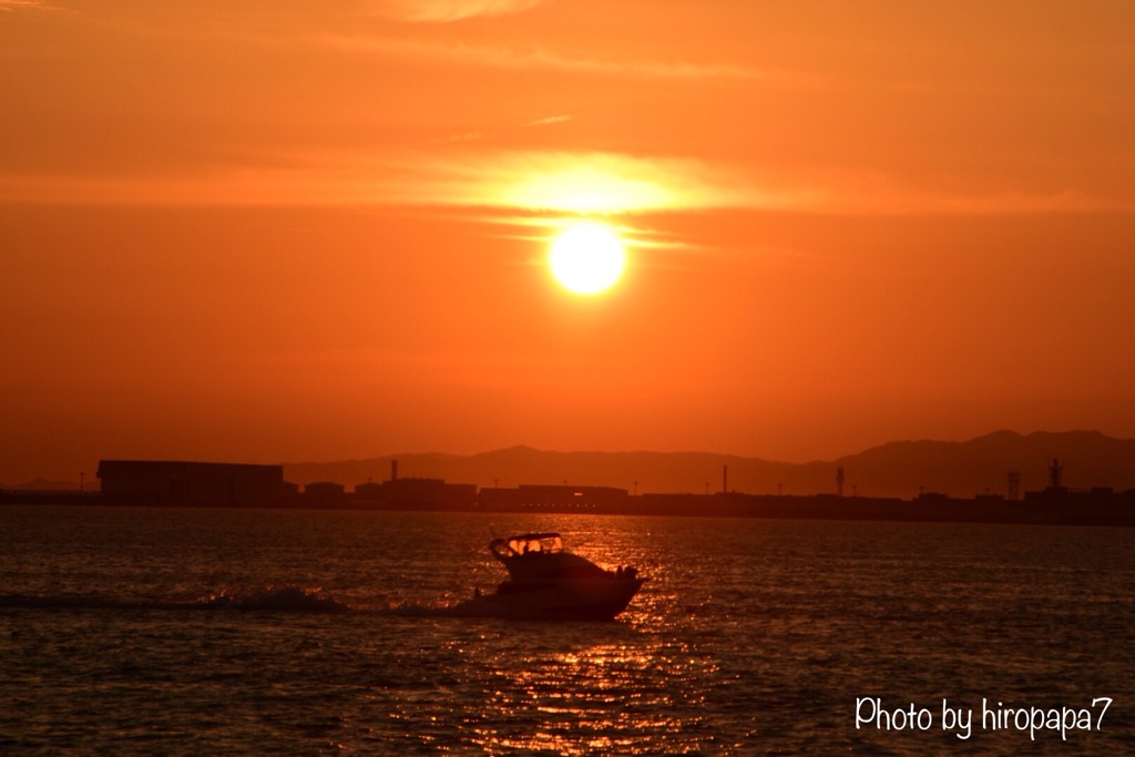 夕焼けに染まる海を突き進む