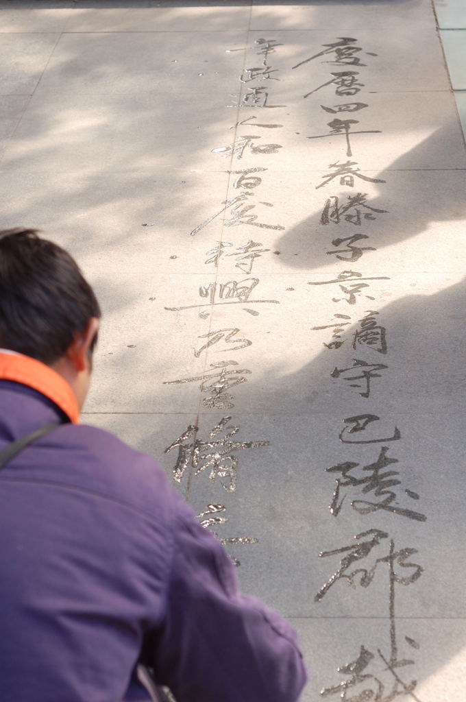 地面に文字を書くおじさん