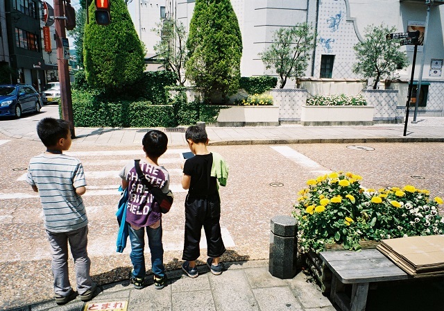 服を肩にかける少年　