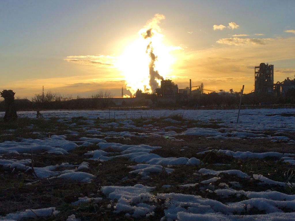 凍てつく畑と朝日に燃えるセメント工場