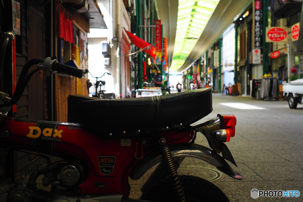 小さなバイク越しに見た商店街
