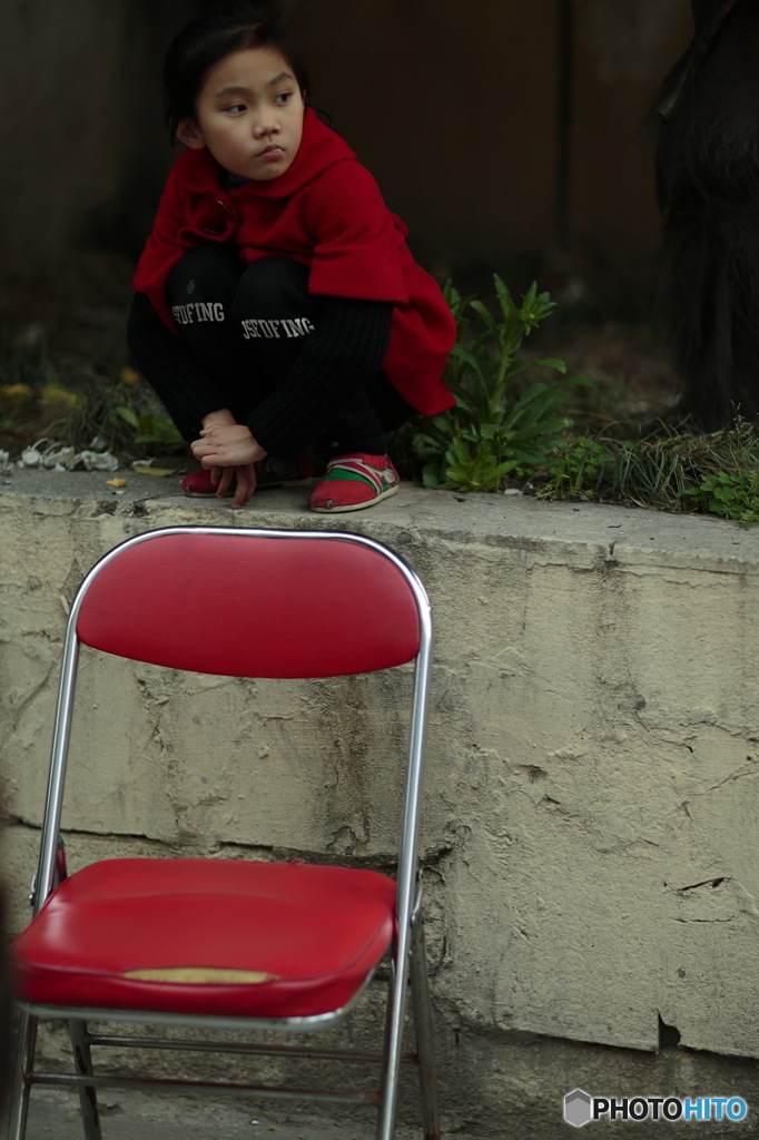 赤い椅子と見つめる少女