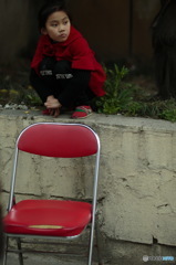 赤い椅子と見つめる少女