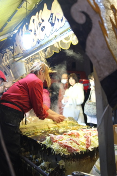 懸命にお好み焼きを焼くお姉さん