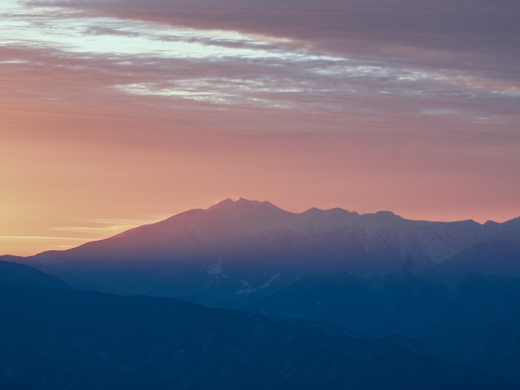 夕陽に染まる雲と山