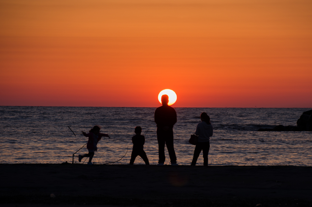 夕日に向かう家族