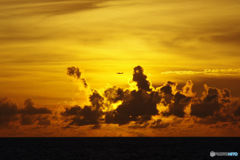 夕陽を飛ぶ飛行機